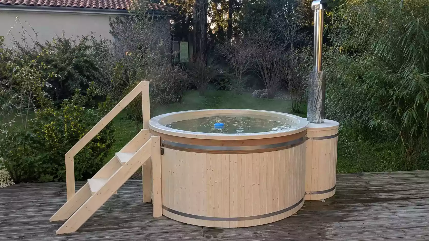 Bain nordique en bois avec poêle dans un jardin