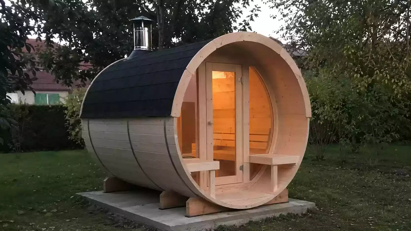 Sauna tonneau extérieur Palmako Anita 4 places en bois avec porte vitrée et poêle, éclairé en fin de journée