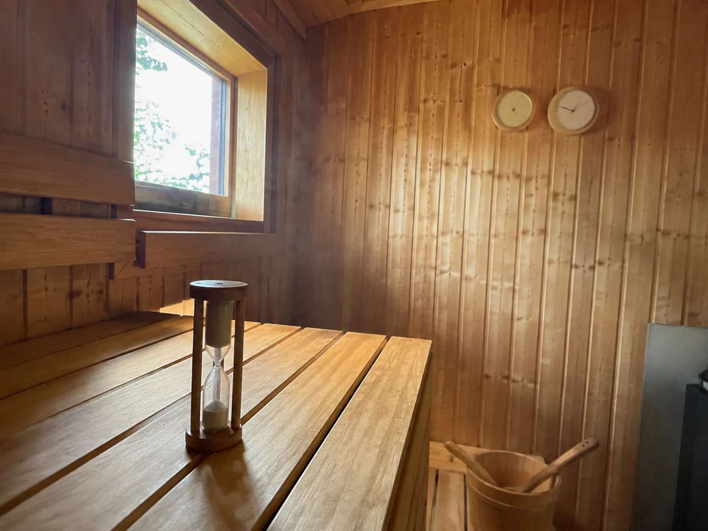 Sablier posé sur la banquette en bois d&rsquo;un sauna