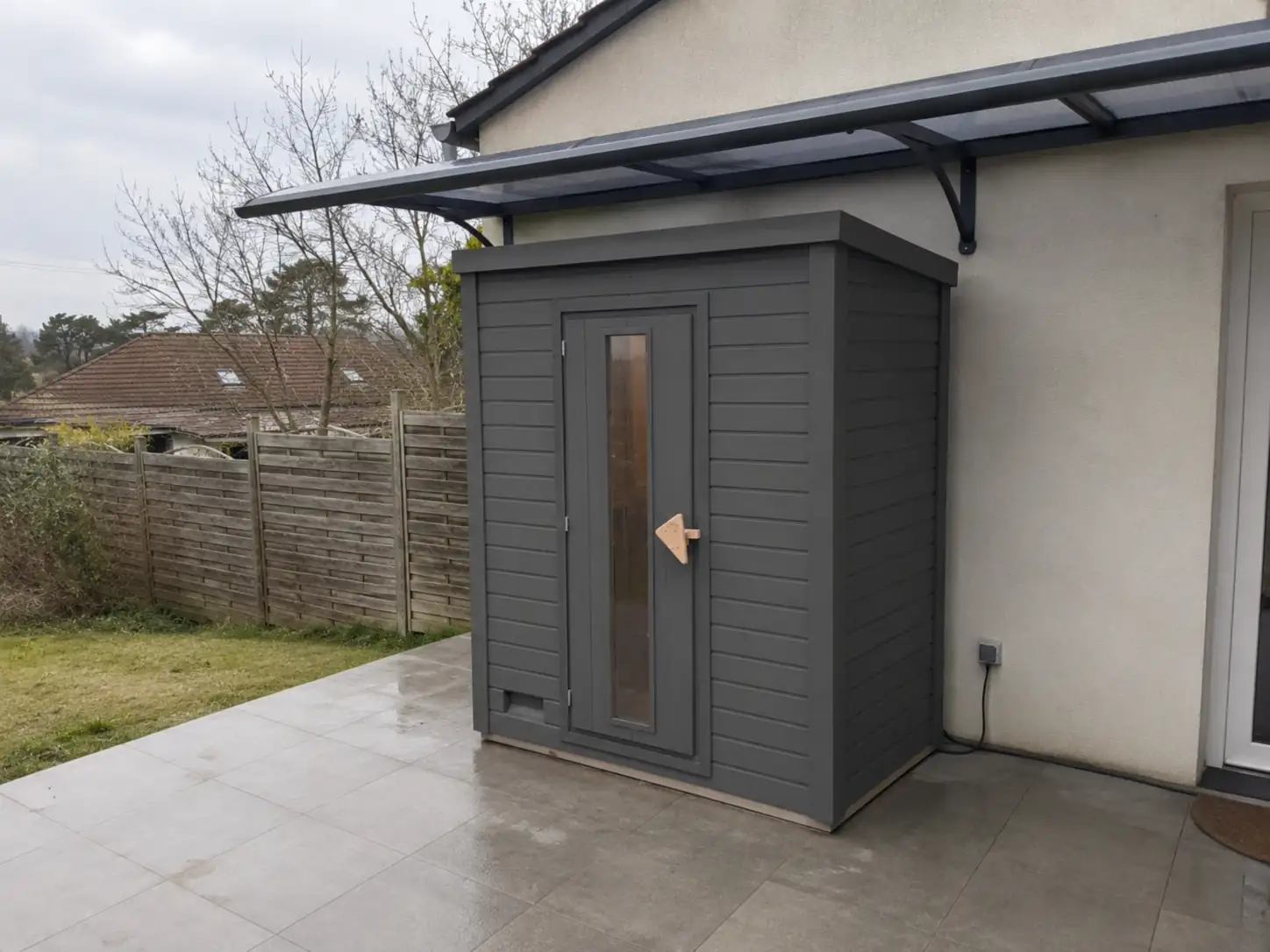 Sauna extérieur Karibu Hytti anthracite installé sur une terrasse