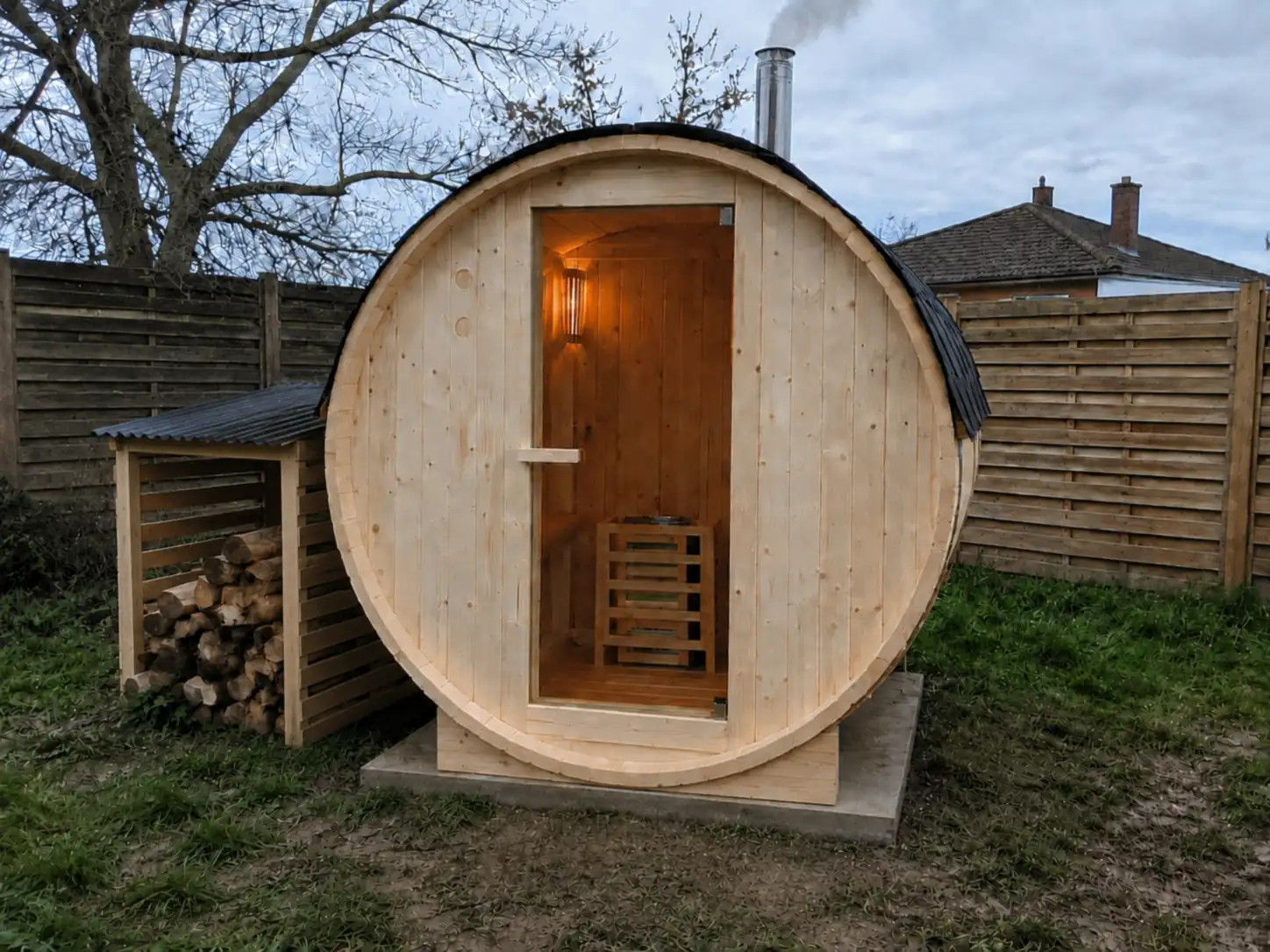 Sauna tonneau Home Deluxe Lahti M de 195 x 120 cm dans un jardin